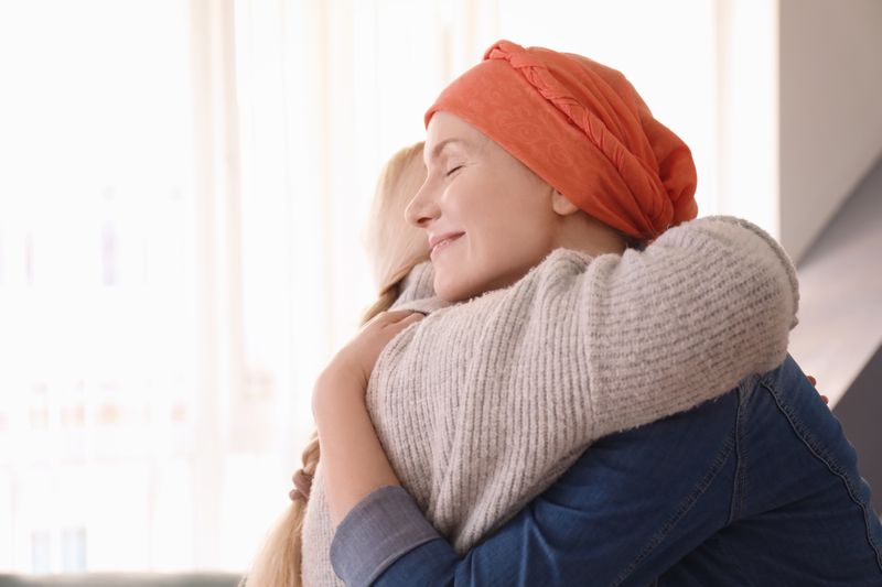 Peaceful cancer survivor giving her daughter a hug