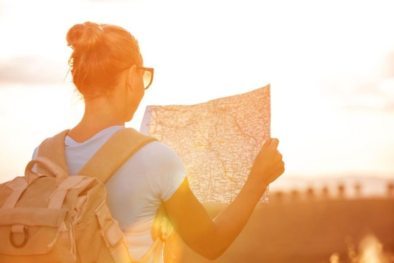 Lost female traveller reading confusing road map