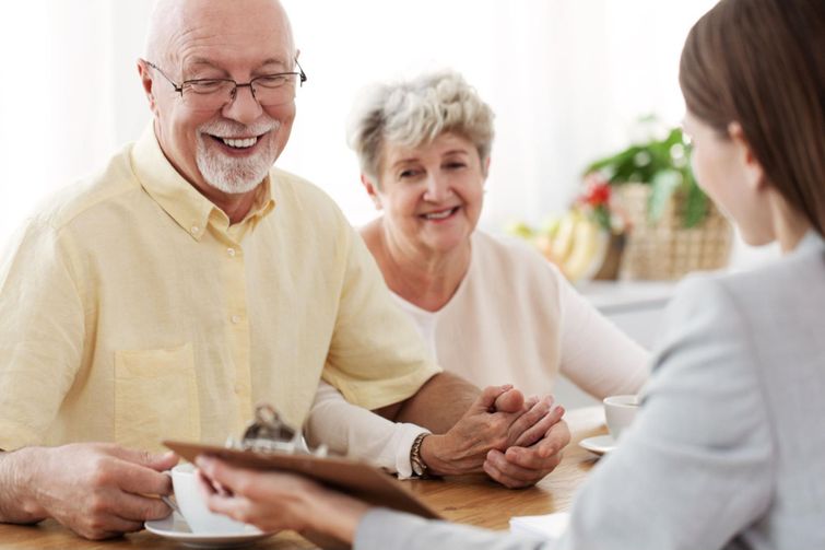 Cheerful elderly couple discussing no-medical life insurance with qualified broker